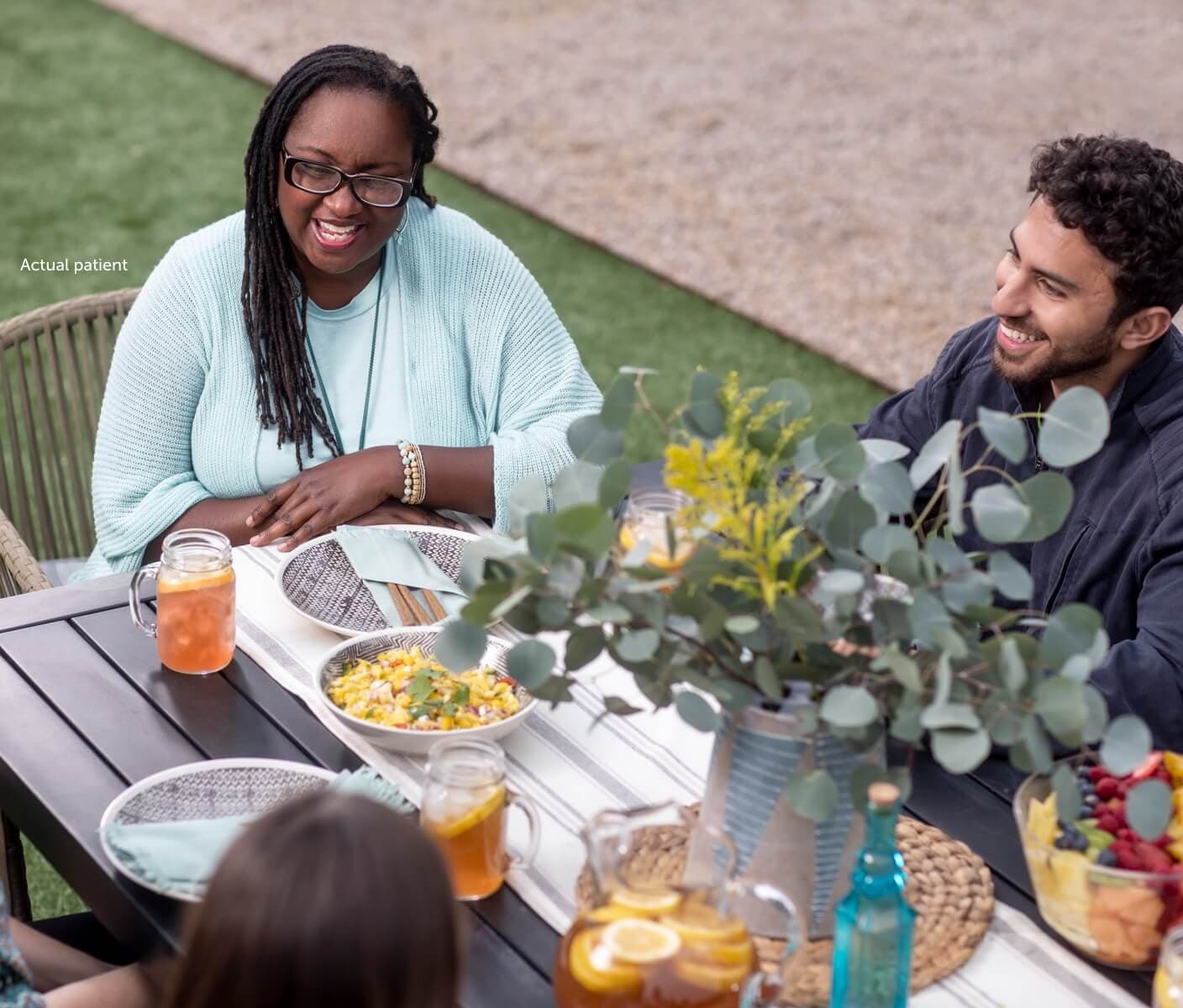 Real VWD patient Erica sitting around the table with her family and friends.