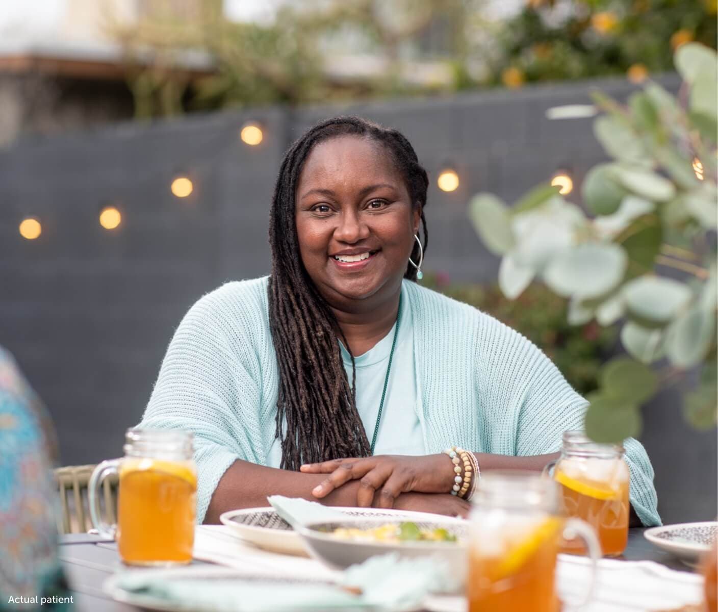 Erica, a real VWD patient sitting at a table smiling.