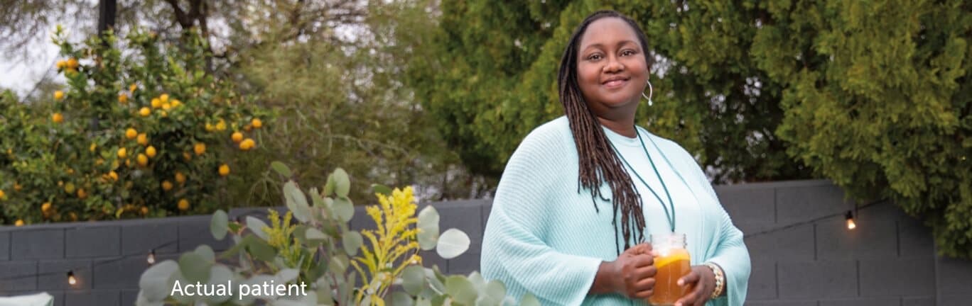 Real VWD patient, Erica standing next to some flowers and smiling. VONVENDI® can be used for on-demand use.