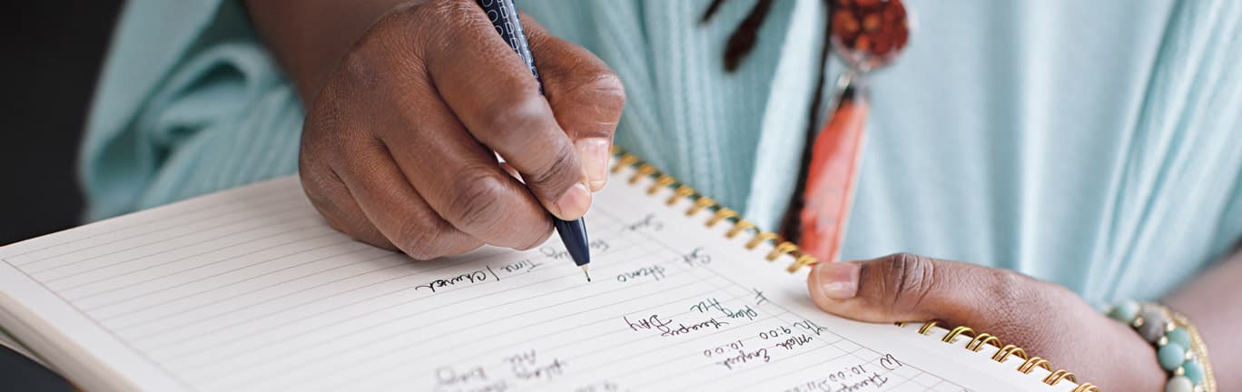 Woman handwriting notes in her journal.