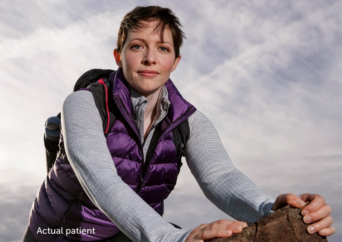 Leslie, a real VWD patient resting on a rock.