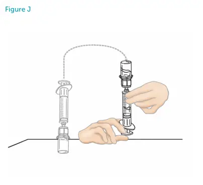 Hands flipping the vial on top of the syringe.